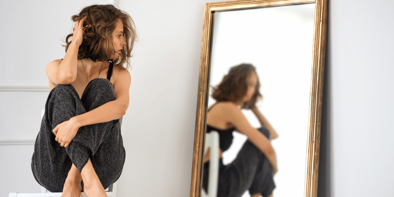 A person looking in the mirror, with a sense of self-reflection and understanding